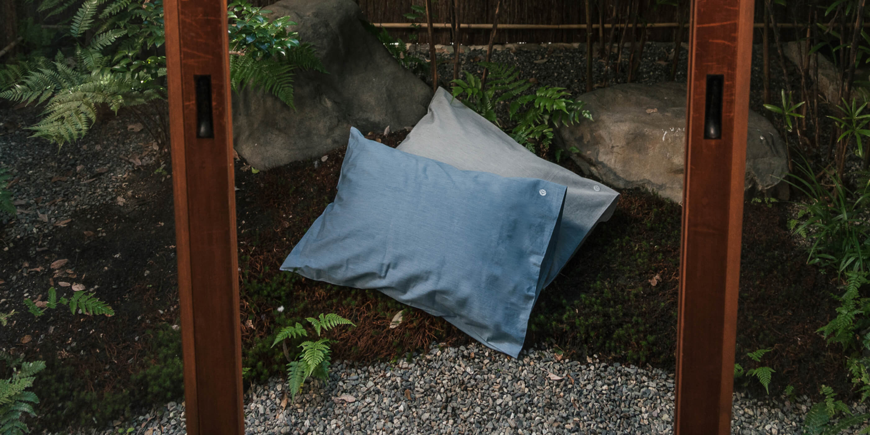 Aizome Pillowcases in two different colourways are laying on the ground in an beautiful garden